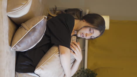 Vertical-video-of-Depressed-young-woman-lying-on-the-sofa.